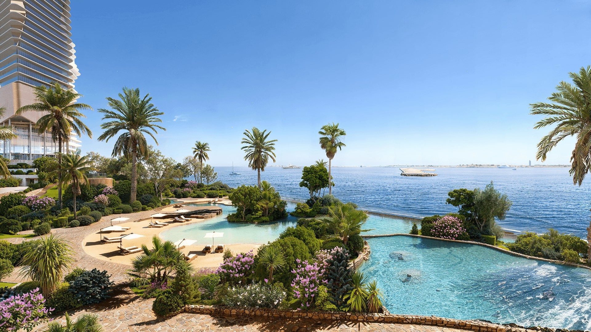 Scenic view of a pool area with palm trees and ocean in the background