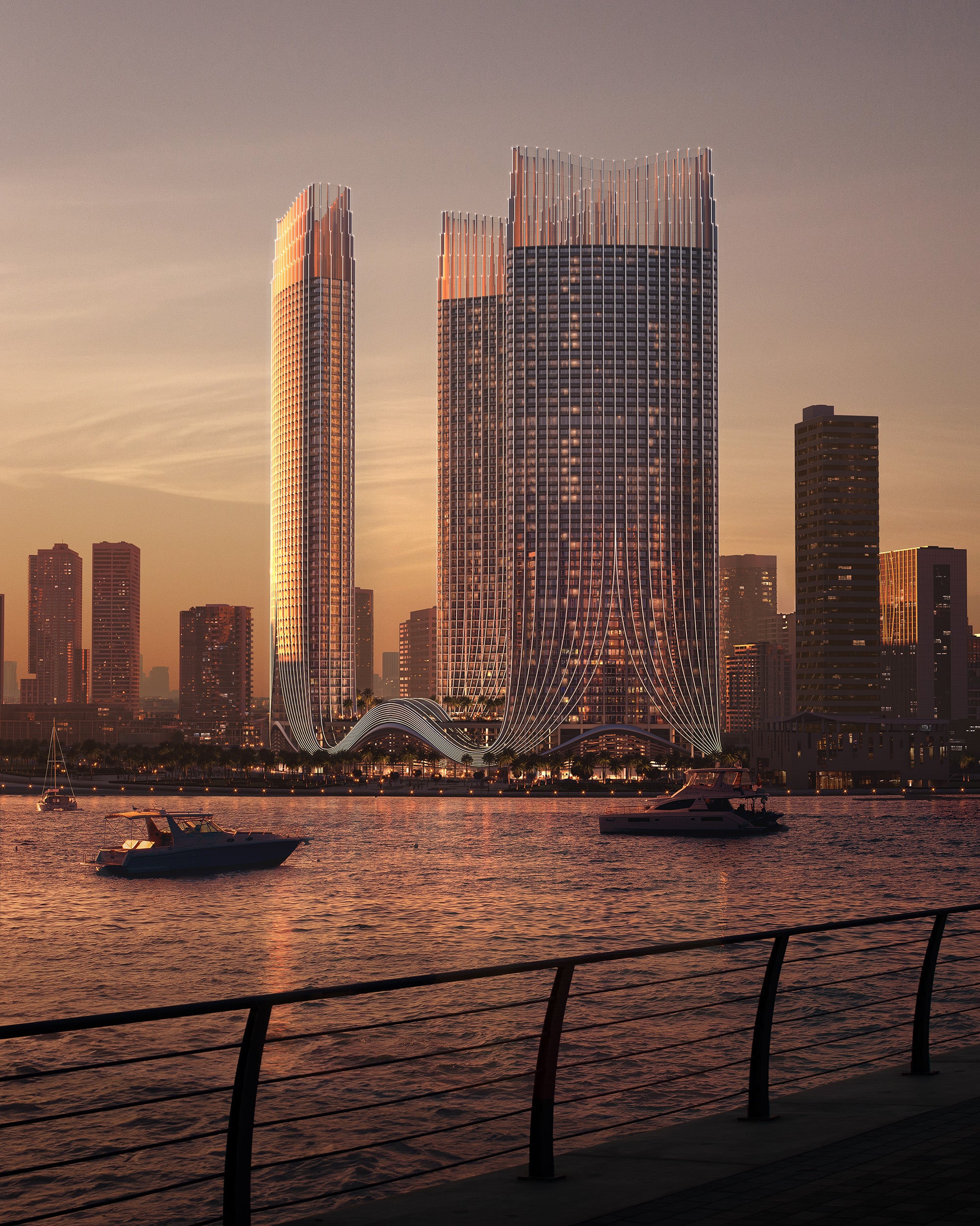 Three tall Binghatti Skyrise skyscrapers with a sunset skyline and water in the foreground