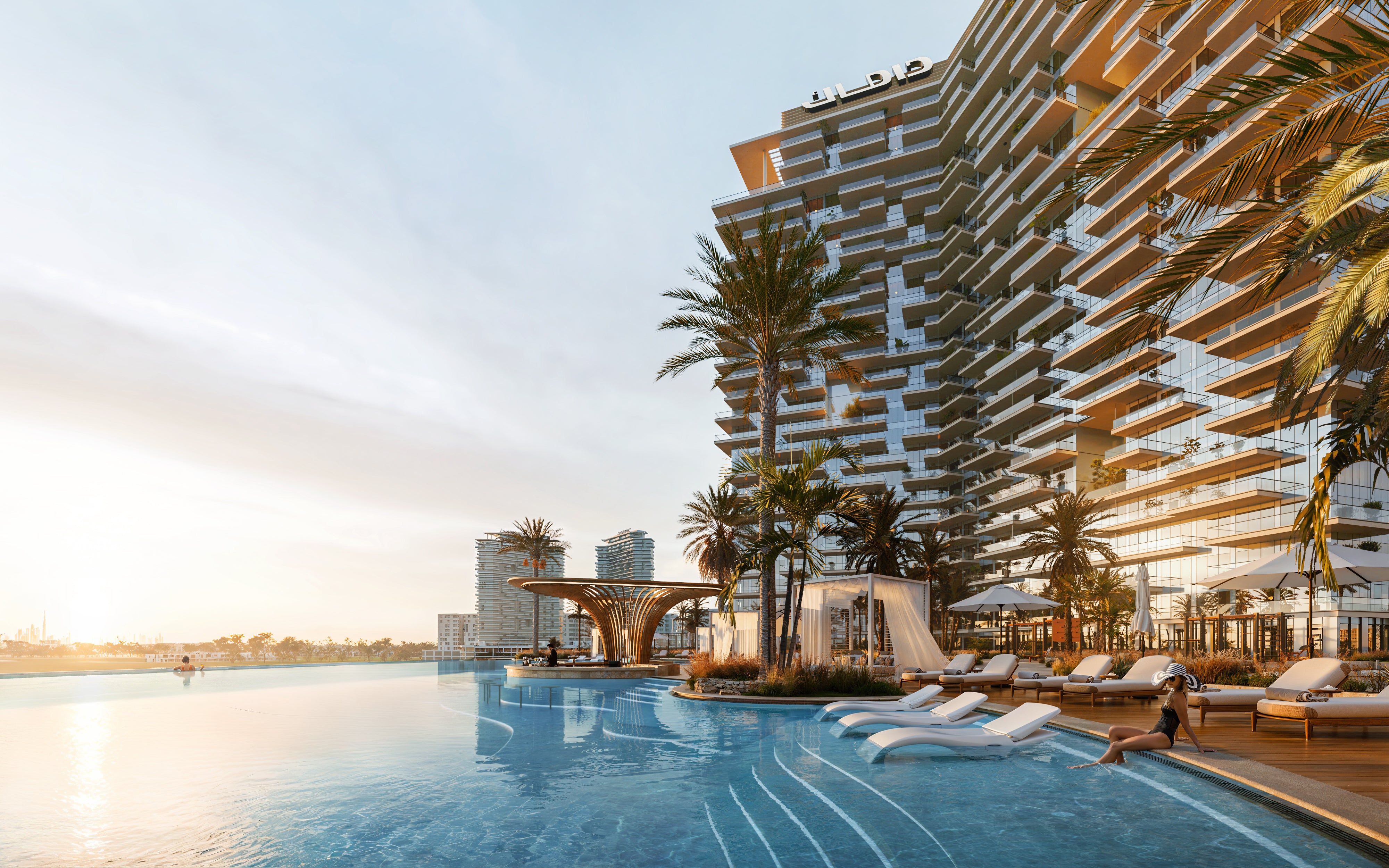Modern apartment complex pool area with lounge chairs and palm trees by a waterfront.